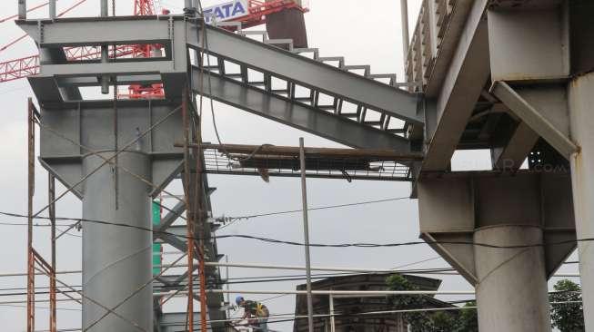 Pekerja menyelesaikan pembangunan jembatan penyeberangan orang (JPO) di sekitar Stasiun Tanjung Barat, Jakarta, Jumat (29/9).