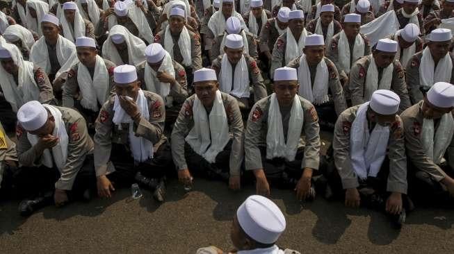 Ratusan anggota polisi dari kesatuan Brimob berkopiah dan bersorban menggelar zikir di depan gerbang gedung DPR RI, Jakarta, Jumat (29/9).