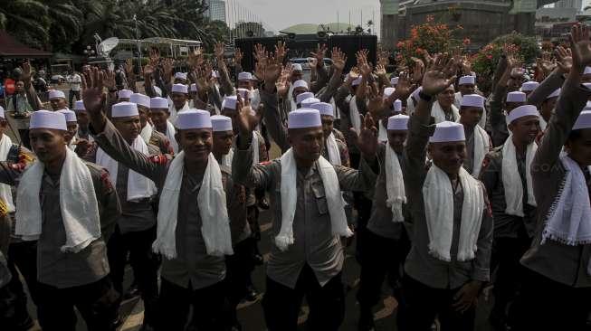 Ratusan anggota polisi dari kesatuan Brimob berkopiah dan bersorban menggelar zikir di depan gerbang gedung DPR RI, Jakarta, Jumat (29/9).