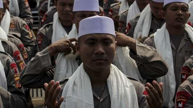 Ratusan anggota polisi dari kesatuan Brimob berkopiah dan bersorban menggelar zikir di depan gerbang gedung DPR RI, Jakarta, Jumat (29/9).