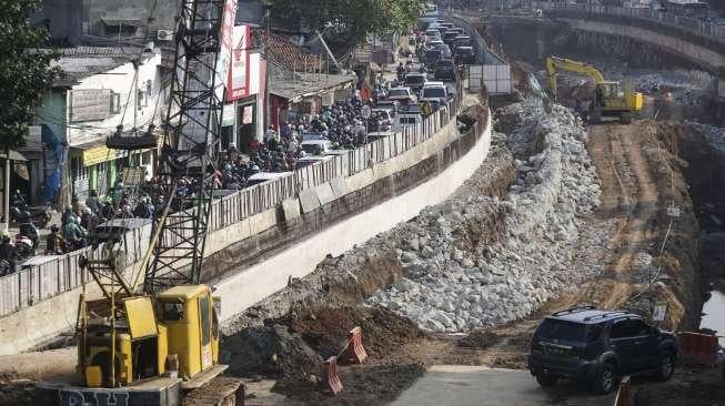 Pekerja menggunakan alat berat terlihat menyelesaikan pembangunan Underpass Mampang-Kuningan di Jakarta, Sabtu (30/9/2017). [Suara.com/Kurniawan Mas'ud]