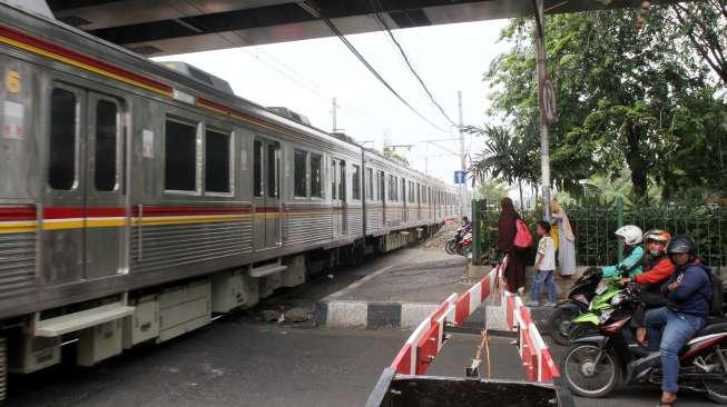 Sejumlah kendaraan melintas di perlintasan kereta api di Jalan KH Hasyim Ashari, Cideng, Jakarta, Minggu (1/10).