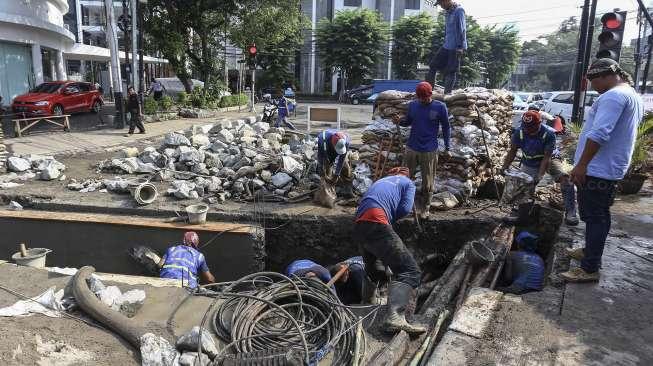 Petugas Suku Dinas Sumber Daya (SDA) Jakarta Pusat membuat sodetan untuk saluran di Jalan KH Wahid Hasyim, Kebon Sirih, Jakarta, Selasa (3/10).