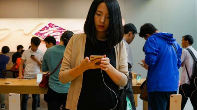 Seorang perempuan di Cina sedang melihat-lihat iPhone 8 di sebuah gerai Apple di Shanghai pada 22 September lalu. [AFP/Chandan Khanna]