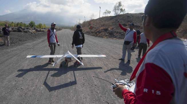 Anggota tim pengendali pesawat tanpa awak bersiap menerbangkan pesawat jenis Koak 3.0 untuk memantau kondisi kawah Gunung Agung di Desa Dukuh, Karangasem, Bali, Kamis (12/10).