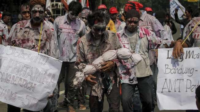 Puluhan awak buruh mobil tangki Pertamina yang terkena PHK menggelar aksi longmarch dari Bandung-Jakarta di Bundaran Patung Kuda menuju Istana Negara, Jakarta, Jumat, (21/10).