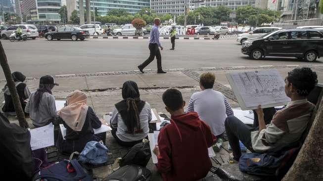 Sejumlah mahasiswa Fakultas Seni Rupa Institut Kesenian Jakarta (IKJ) mengikuti ujian praktek menggambar di kawasan Bundaran HI, Jakarta, Kamis (19/10/2017). [Suara.com/Kurniawan Mas'ud]