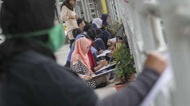 Para mahasiswa Fakultas Seni Rupa Institut Kesenian Jakarta (IKJ) mengikuti ujian praktek menggambar di kawasan Bundaran HI, Jakarta, Kamis (19/10/2017). [Suara.com/Kurniawan Mas'ud]