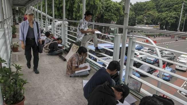 Mahasiswa Fakultas Seni Rupa Institut Kesenian Jakarta (IKJ) terlihat mengikuti ujian praktek menggambar di kawasan Bundaran HI, Jakarta, Kamis (19/10/2017). [Suara.com/Kurniawan Mas'ud]