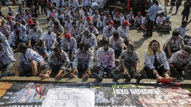 Puluhan awak buruh mobil tangki Pertamina yang terkena PHK menggelar aksi longmarch dari Bandung-Jakarta di Bundaran Patung Kuda menuju Istana Negara, Jakarta, Jumat, (21/10).