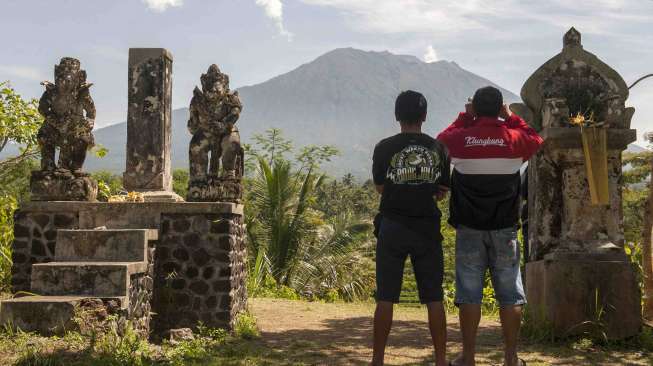 Warga turut memantau Gunung Agung yang bertepatan satu bulan berstatus awas di Pos Pengamatan Gunung Api Agung Desa Rendang, Karangasem, Bali, Sabtu (21/10).