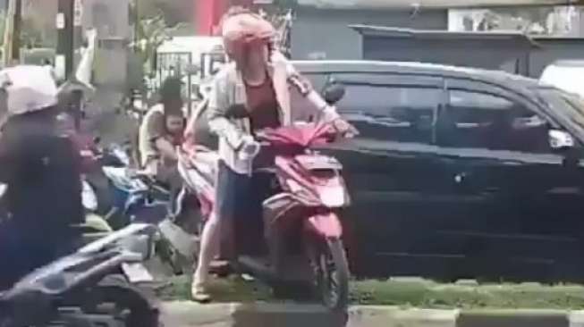 Aksi Emak-emak Naik Pembatas Jalan Ini Bikin Tepok Jidat