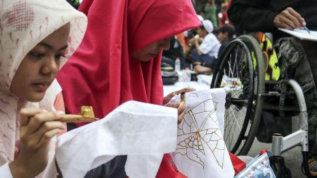 Sejumlah pengunjung car free day (CFD) belajar cara membuat batik di kawasan Bundaran HI, Jakarta, Minggu (22/10/2017). [Suara.com/Kurniawan Mas'ud]