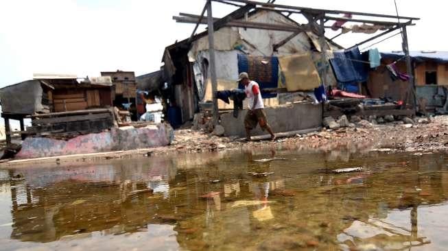 Warga beraktivitas di depan rumah semi permanen di Kampung Akuarium, Jakarta Utara, Selasa (24/10).