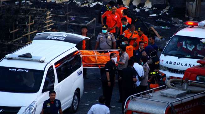 Petugas PMI dan Basarnas mengevakuasi jenazah korban kebakaran pabrik kembang api di Kosambi, Tangerang, Banten, Kamis (26/10).