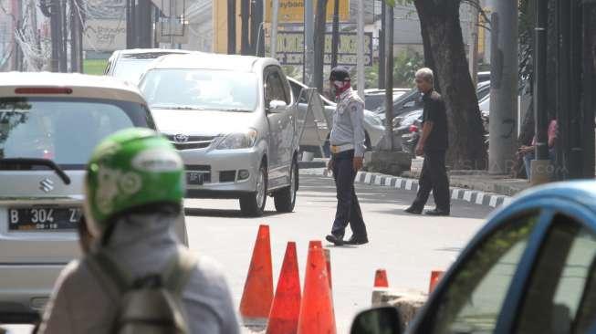 Petugas dinas Perhubungan melakukan pengalihan arus kendaraan saat melakukan uji coba sistem satu arah (SSA) di sepanjang Jalan Melawai, Jakarta, Jumat (27/10).