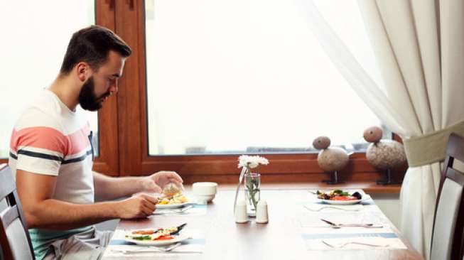 Ilustrasi lelaki makan sendirian. (Shutterstock)