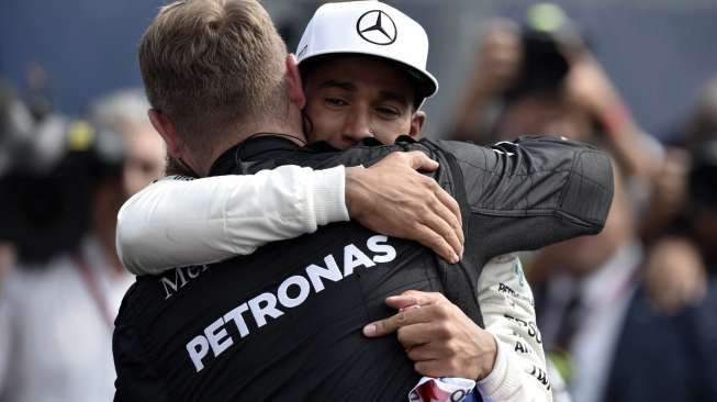 Pebalap Mercedes asal Inggris, Lewis Hamilton, merayakan capaian Juara Dunia Formula 1 (F1) musim 2017 bersama rekan timnya, usai finis di posisi kesembilan di Sirkuit Hermanos Rodriguez, GP Meksiko, Minggu (29/10/2017) waktu setempat. [Yuri Cortez/AFP]