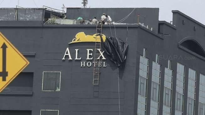 Pekerja menutup logo Hotel Alexis yang terletak di kawasan Pademangan, Ancol, Jakarta, Selasa (31/10).