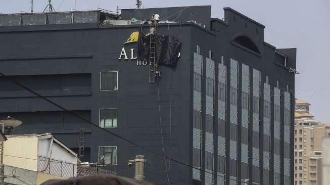 Pekerja menutup logo Hotel Alexis yang terletak di kawasan Pademangan, Ancol, Jakarta, Selasa (31/10).