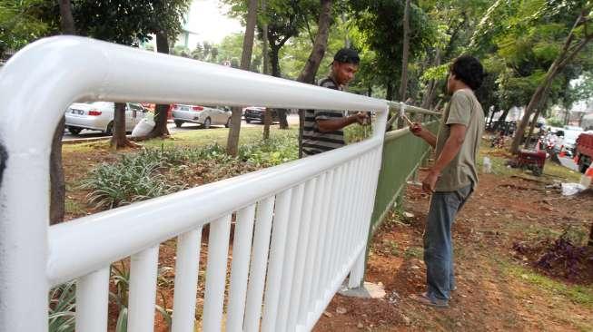 Pekerja memasang pagar pembatas jalan di kawasan Tebet, Jakarta, Jumat,(3/11).