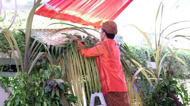 Presiden Joko Widodo dan Ibu Iriana Jokowi serta keluarga memasang bleketepe dan tuwuhan [dok. MDC Jim Boen]