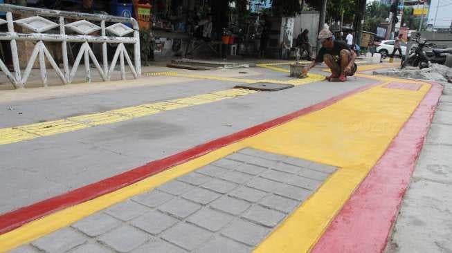 Pekerja melakukan pengecatan trotoar di Gunung Sahari, Jakarta, Selasa (7/11).