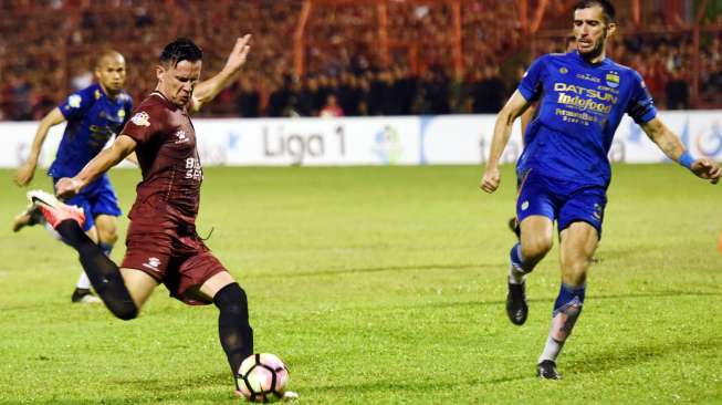 Pemain PSM Makassar Pavel Purishkin (kiri) melepaskan tendangan yang coba dihambat bek Persib Bandung Vladimir Vujovic (kanan) pada laga Liga 1 yang berakhir 2-1 di Stadion Andi Mattalatta, Makassar, Sulawesi Selatan, Minggu (15/10). [Antara]