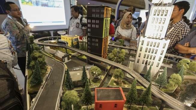 Pengunjung menyaksikan berbagai maket, rancangan dan objek lain dalam pameran infrastruktur yang digelar di Jakarta Convention Center (JCC), Senayan, Jakarta, Rabu (8/11/2017). [Suara.com/Kurniawan Mas'ud]