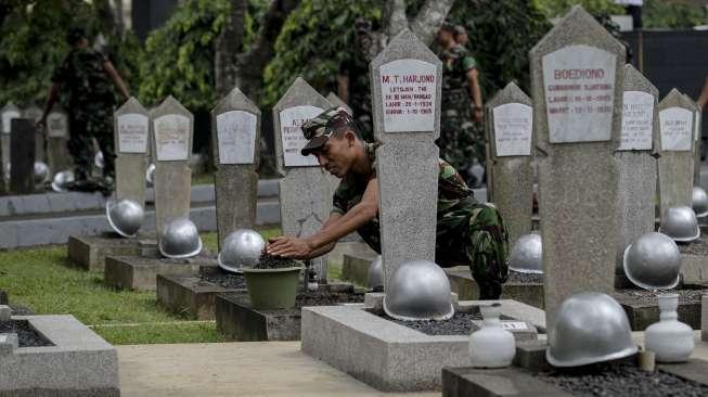 Anggota TNI Garnisun se-Jabodetabek terlibat dalam kegiatan membersihkan area Taman Makam Pahlawan (TMP) Kalibata, di Jakarta, Kamis (9/11/2017), jelang peringatan Hari Pahlawan. [Suara.com/Kurniawan Mas'ud]