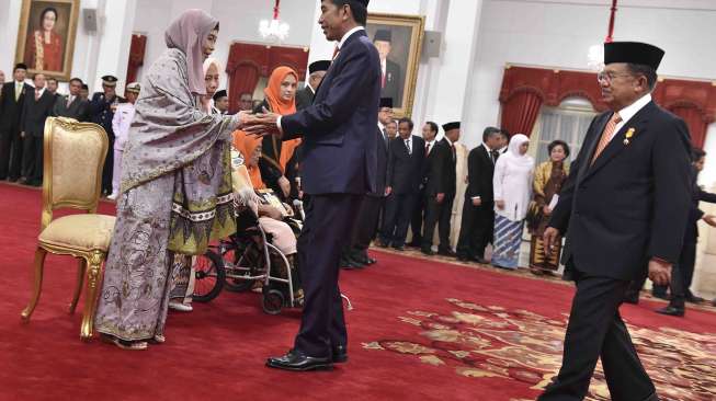 Presiden Joko Widodo menyerahkan tanda jasa saat penganugerahan gelar pahlawan di Istana Negara, Jakarta, Kamis (9/11).