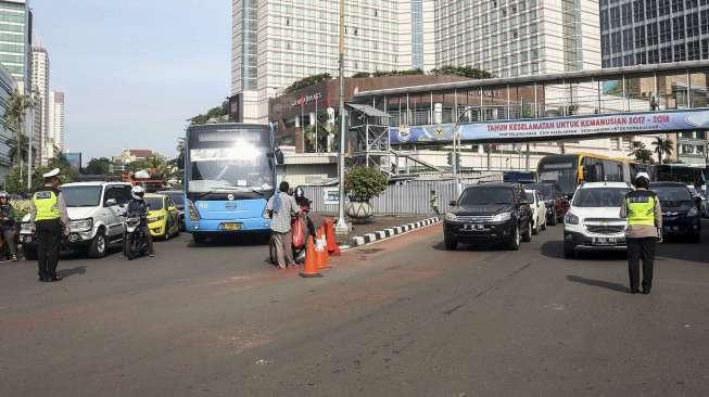 Polisi Lalu lintas memberhentikan kendaraan yang melintas untuk mengheningkan cipta sejenak di kawasan Bundaran HoteI Indonesia, Jakarta, Jumat (10/11).