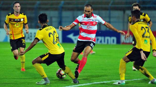 Striker Madura United, Peter Odemwingie (tengah), berusaha melewati bek Barito Putra, Hansamu Yama (kanan) dan Nazar Nurzaidin (kedua kiri) kala bertemu dalam lanjutan Liga 1 di Stadion Gelora Bangkalan (SGB) Bangkalan, Jawa Timur, (5/11). [Antara]