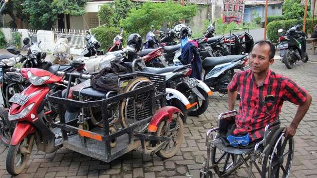 Catur Bambang, pemilik bengkel Modifikasi Motor Roda 3 khusus difabel, saat berada di bengkel miliknya, di kawasan Bintaro, Sabtu (11/11/2017). [Suara.com/Oke Atmaja]