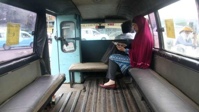 Seorang penumpang di dalam angkot yang sedang menunggu penumpang lainnya di Terminal Kampung Melayu, Jakarta Timur, Sabtu (11/11/2017). [Suara.com/Oke Atmaja]