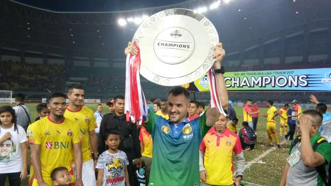 Pelatih Bhayangkara FC Simon Mcmenemy mengangkat trofi Liga 1 usai menghadapi Persija Jakarta di laga penutup. Dalam laga yang digelar di Stadion Patriot, Bhayangkara FC tumbang 1-2 [Suara.com/Adie Prasetyo]