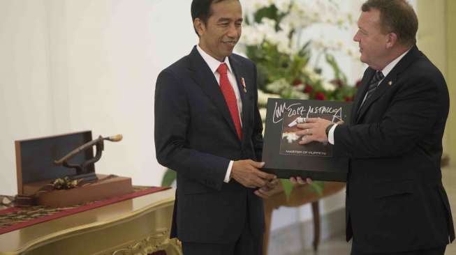 Perdana Menteri Denmark Lars Lokke Rasmussen memberi Presiden Joko Widodo cenderamata berupa piringan hitam band Metallica dalam kunjungan di Istana Bogor, Bogor, Jawa Barat, Selasa (28/11).