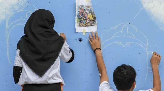 Siswa Sekolah Menengah Kejuruan (SMK) menyelesaikan proyek pembuatan mural di tiang penyangga jalan layang non tol (JLNT) Kasablanka, Jakarta, Jumat (1/12).