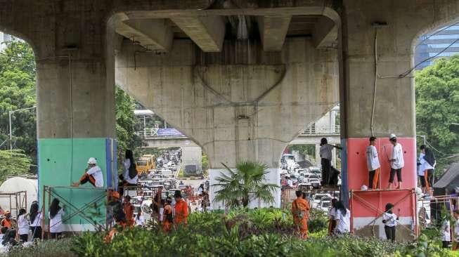 Siswa Sekolah Menengah Kejuruan (SMK) menyelesaikan proyek pembuatan mural di tiang penyangga jalan layang non tol (JLNT) Kasablanka, Jakarta, Jumat (1/12).