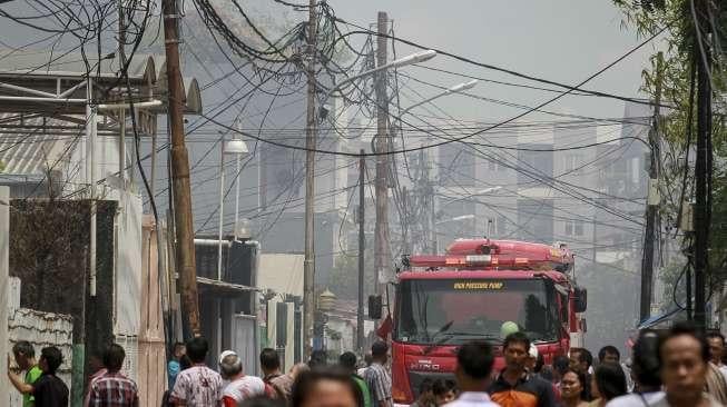 Petugas berusaha memamdamkan sisa api yang membakar sebuah pabrik dan gudang kosmetik di kawasan Tambora, Jakarta, Senin (4/12).