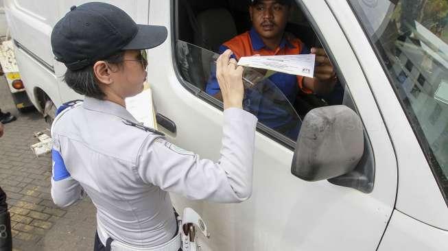 Petugas memasang alat derek pada mobil yang terparkir di kawasan Jalan Proklamasi, Menteng, Jakarta, Selasa (5/12).