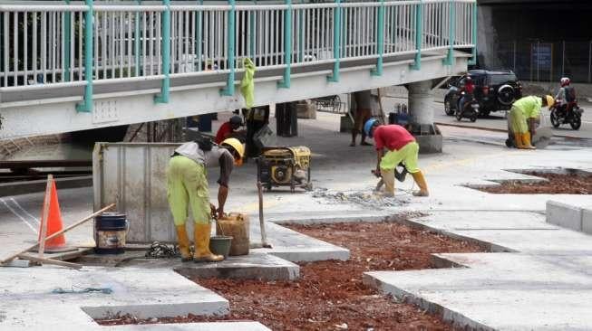 Pekerja menyelesaikan proyek taman 12 Mei reformasi di kawasan Grogol, Jakarta, Rabu (6/12).