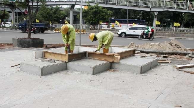 Pekerja menyelesaikan proyek taman 12 Mei reformasi di kawasan Grogol, Jakarta, Rabu (6/12).