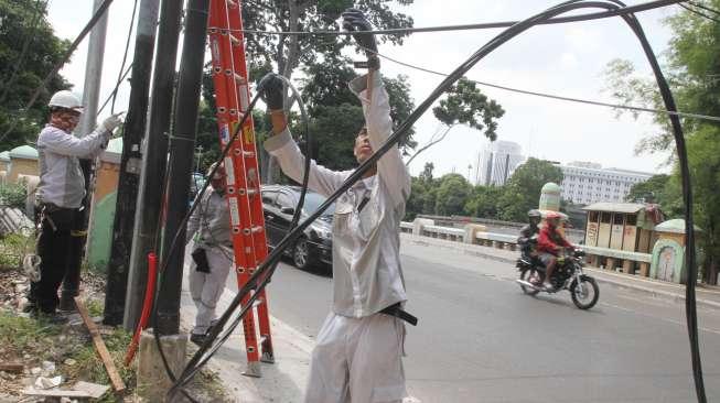 Petugas merapikan kabel di kawasan Gambir, Jakarta, Kamis (7/12).