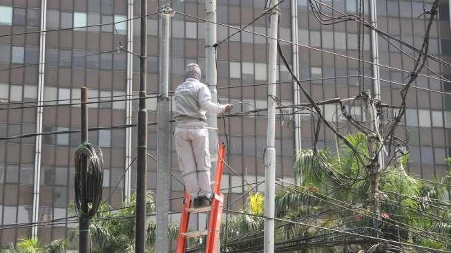 Petugas merapikan kabel di kawasan Gambir, Jakarta, Kamis (7/12).