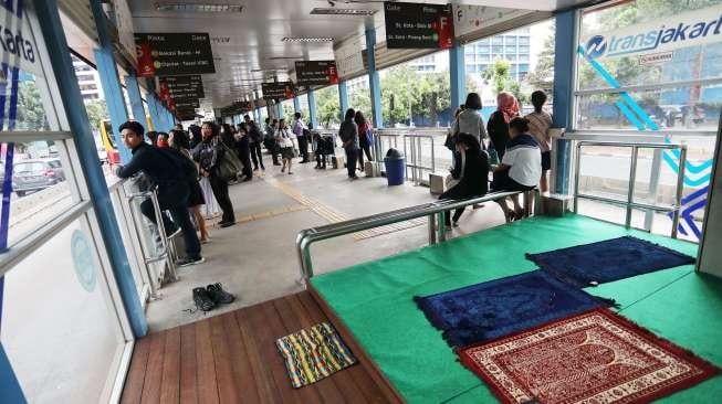 Calon penumpang Transjakarta melaksanakan salat Zuhur di Halte Transjakarta, Karet, Jalan Sudirman, Jakarta Pusat, Sabtu (9/12).