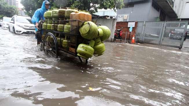 Sejumlah kendaraan menerobos banjir di kawasan Jalan Jaksa, Jakarta, Selasa (12/12).