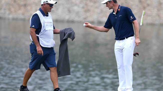 Pegolf peringkat enam dunia asal Inggris Justin Rose memungut bola saat bertanding dalam putaran pertama turnamen golf Indonesian Masters di Royale Jakarta Golf Club, Jakarta Timur, Kamis (14/12).