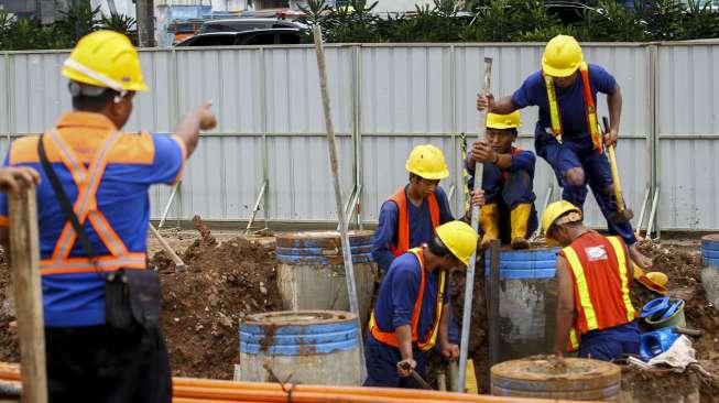 Pekerja memperbaiki saluran pipa air bersih milik PDAM yang bocor di kawasan proyek Jalan Layang Tol Becakayu, Jakarta, Jumat (15/12).