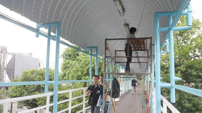 Pemasangan lampu di Jembatan Penyebrangan Orang (JPO) Kenari, Jakarta, Sabtu (15/12).